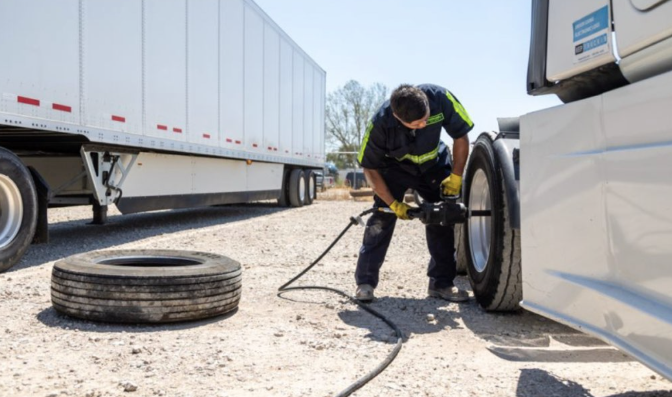 Technician servicing a semi-truck tire on site